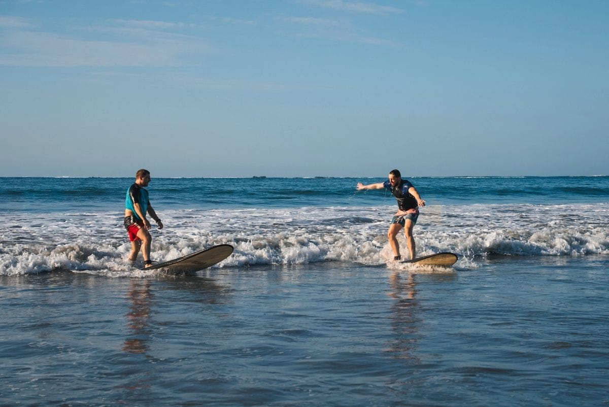 Two surfers riding small waves at a Bali beach break
