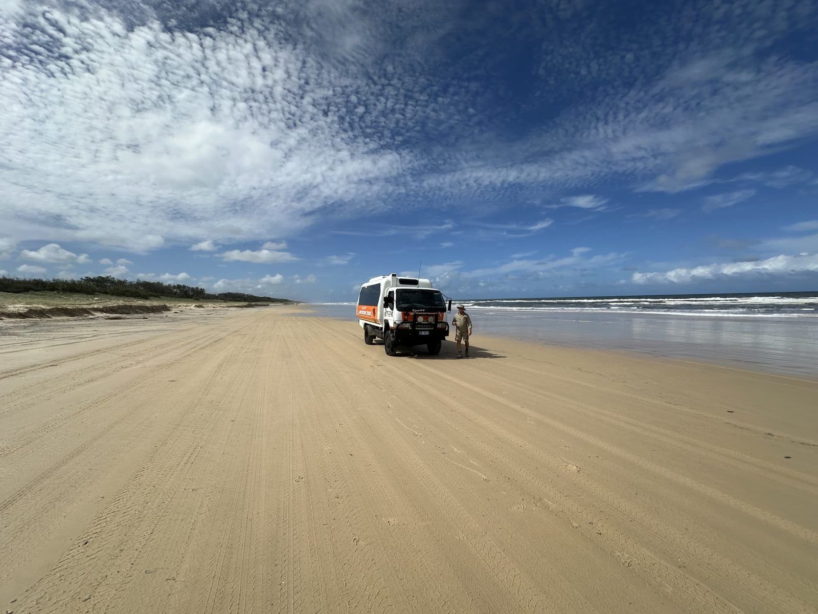 A 4WD driving along 75 Mile Beach on K'gari