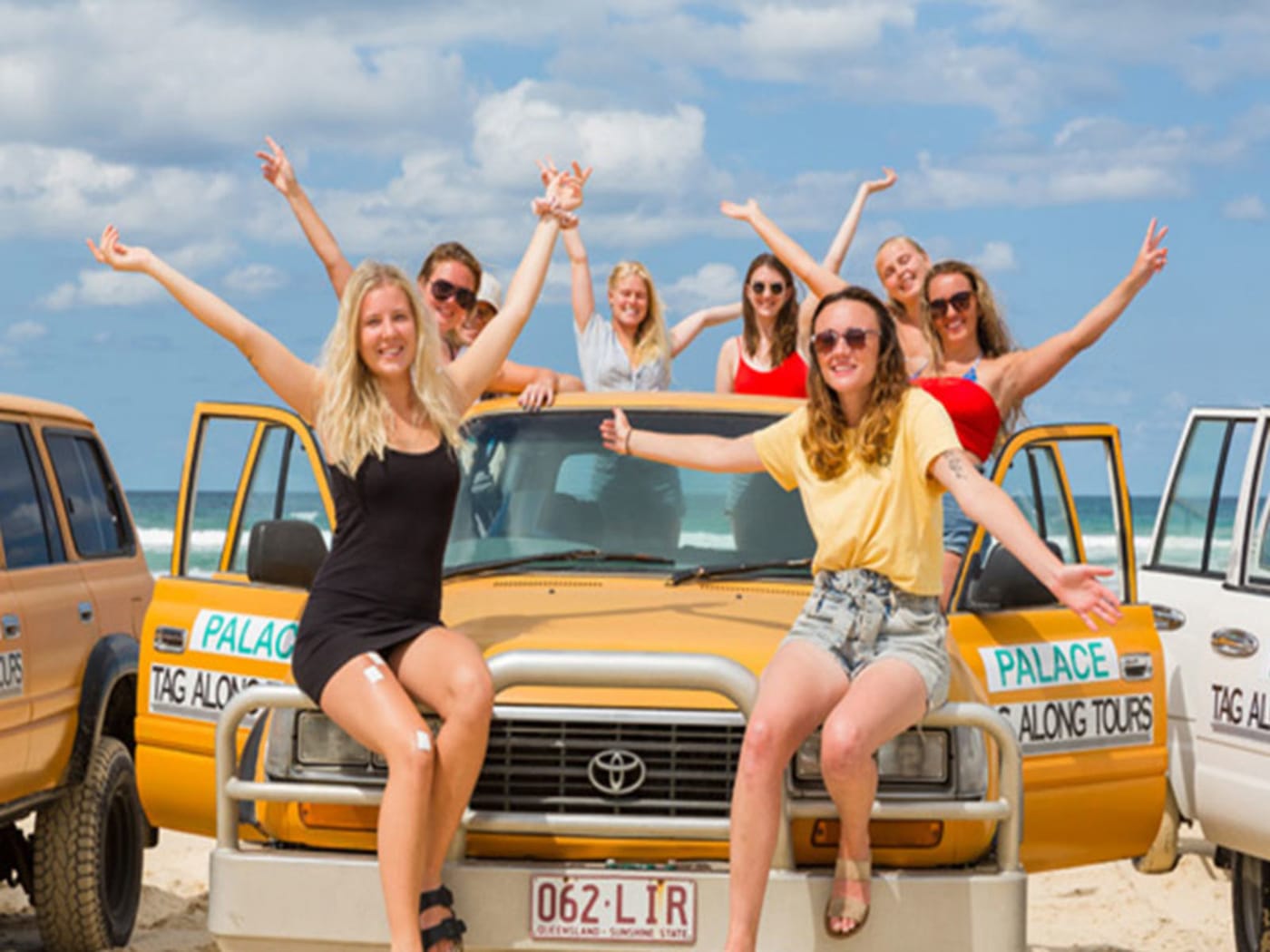 Travellers cheering on their 4WD on a K'gari beach