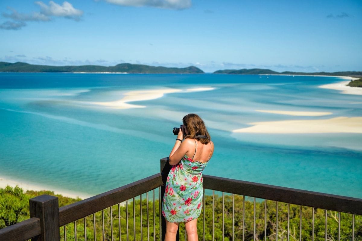 A traveller photographing the swirling sands of Hill Inlet in the Whitsundays
