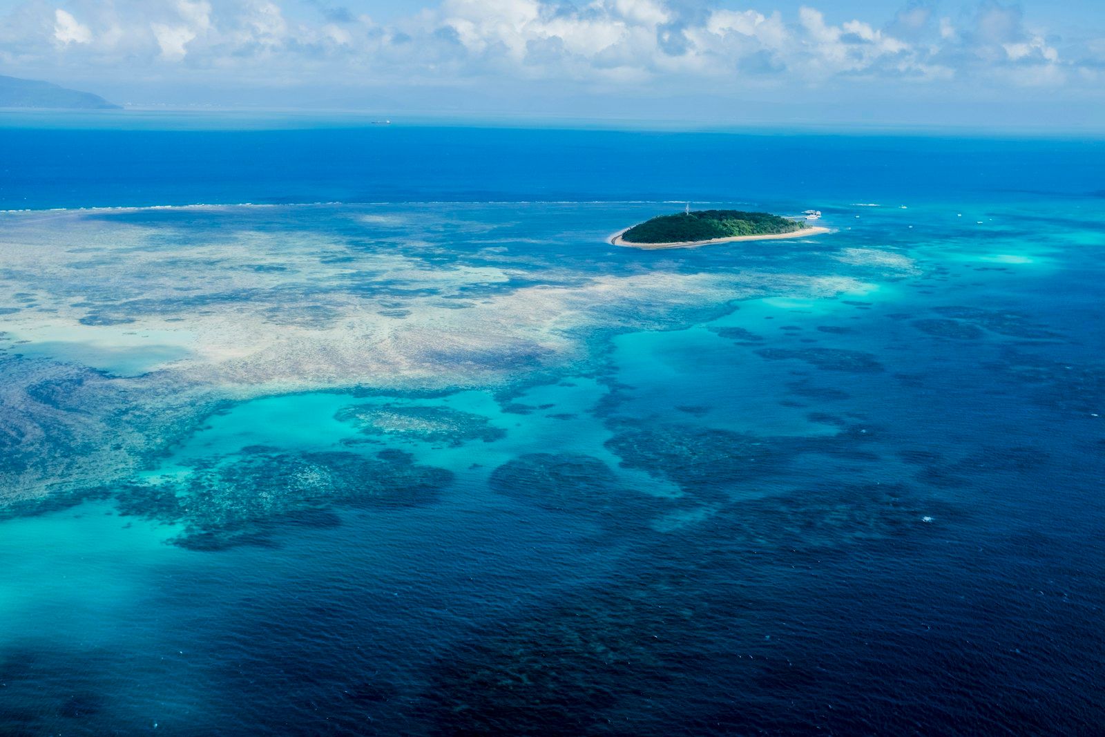 Coral and clear blue water on the Great Barrier Reef seen from above