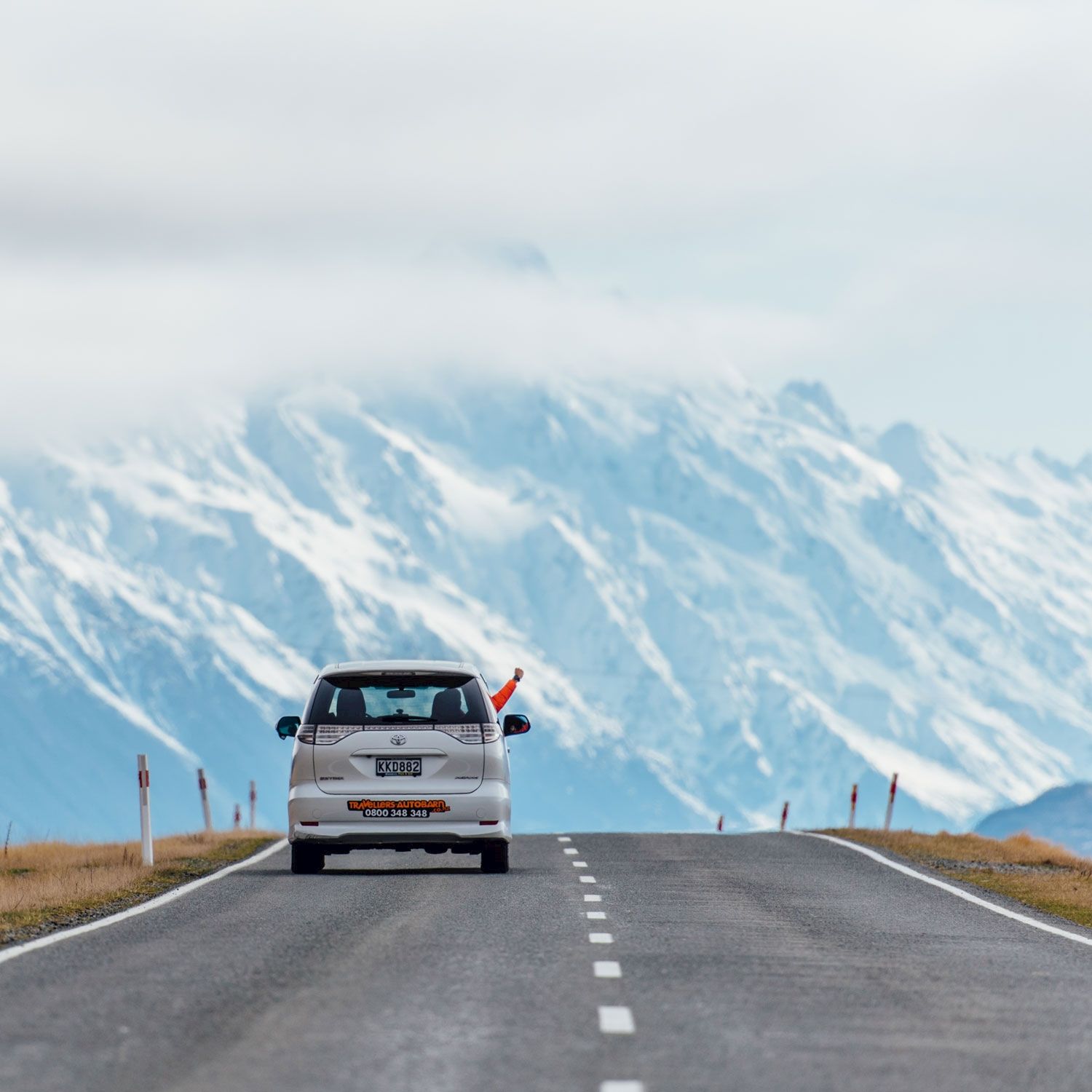 A campervan on an open road through New Zealand hills