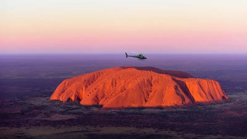 Uluru glowing red at sunrise