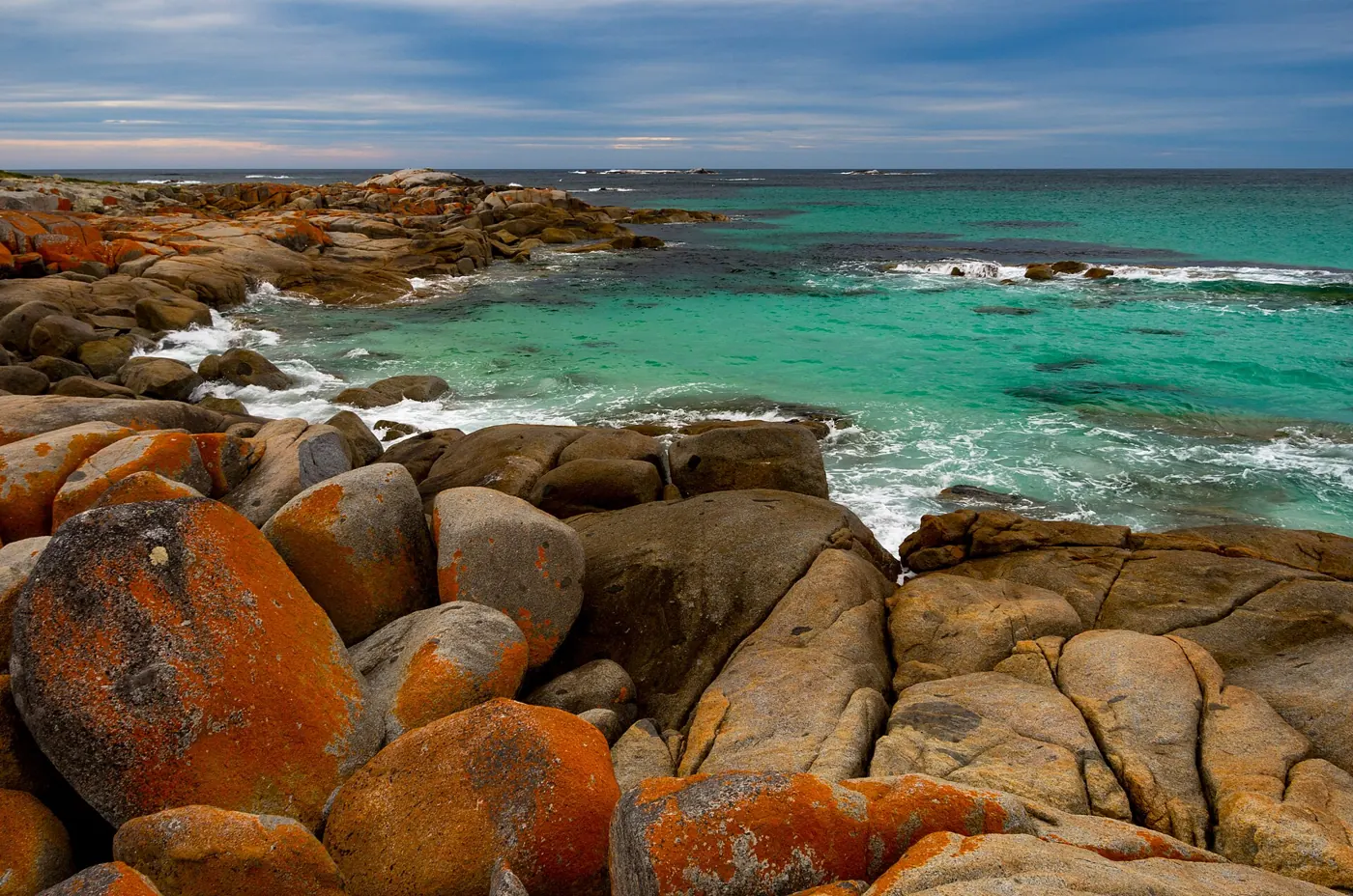 Orange lichen-covered granite at the Bay of Fires